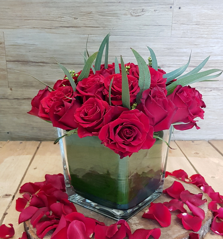 Composizione di rose rosse in vaso di vetro
